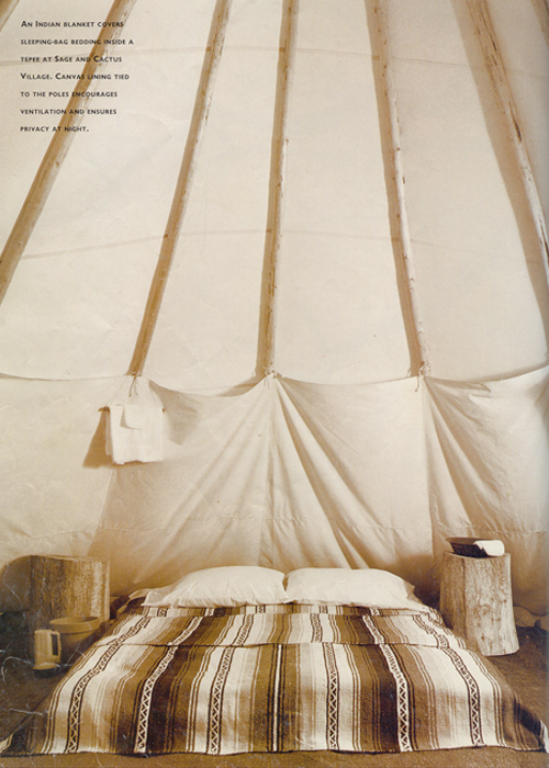 An Indian blanket covers sleeping-bag bedding inside a Tepee at Sage and Cactus Village. Canvas lining tied to the poles encourages ventilation and ensures privacy at night.